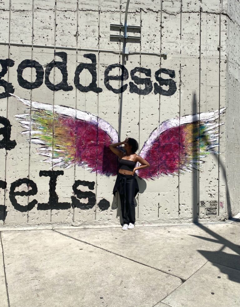 Kayla Janelle Wilder spreading her wings in a stunning shot. Pictured in front of Los Angeles mural on Hope Street
