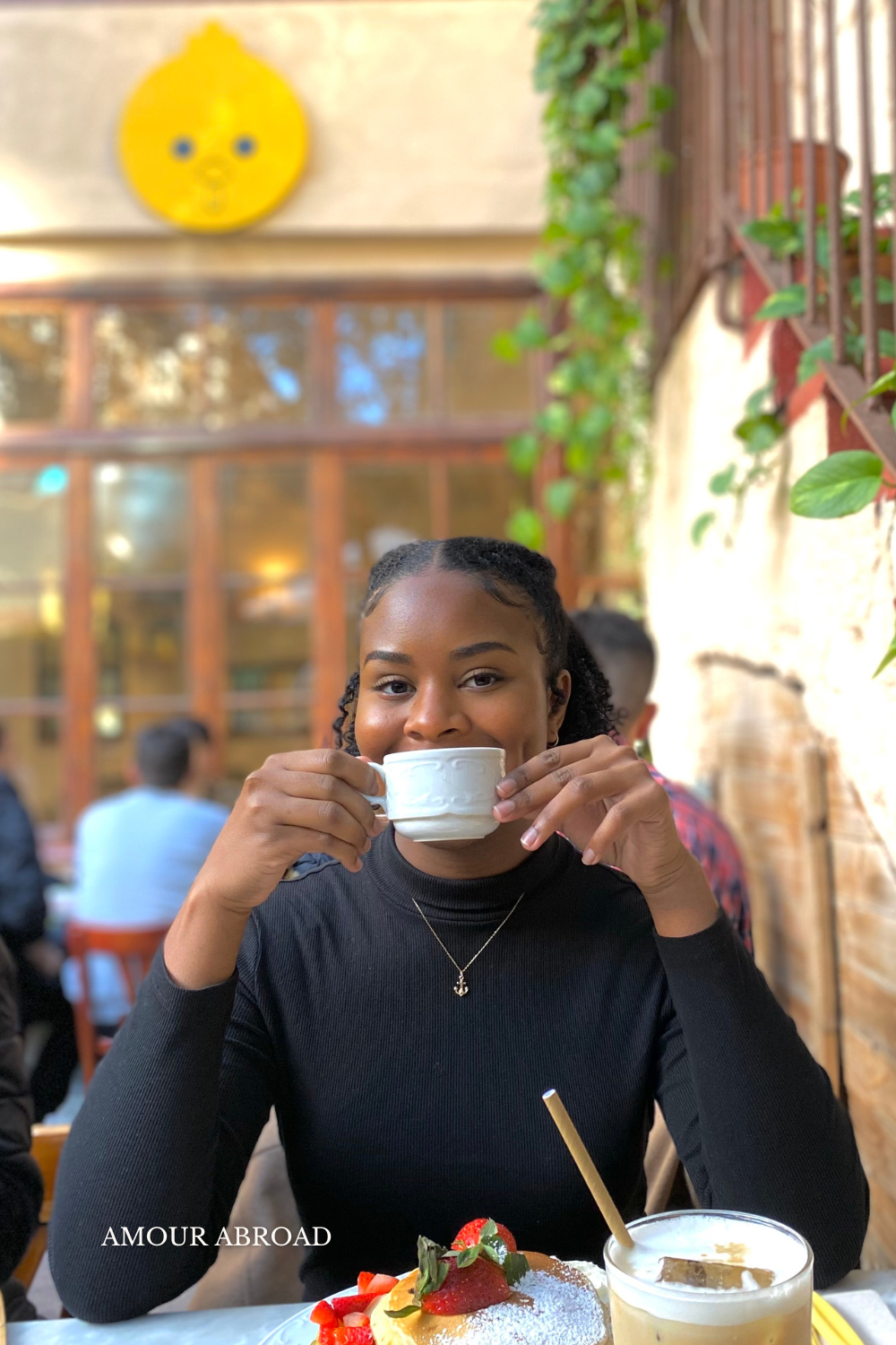 Kayla Wilder smiling over a cup of coffee at Billy Brunch Cafe in Barcelona, Spain