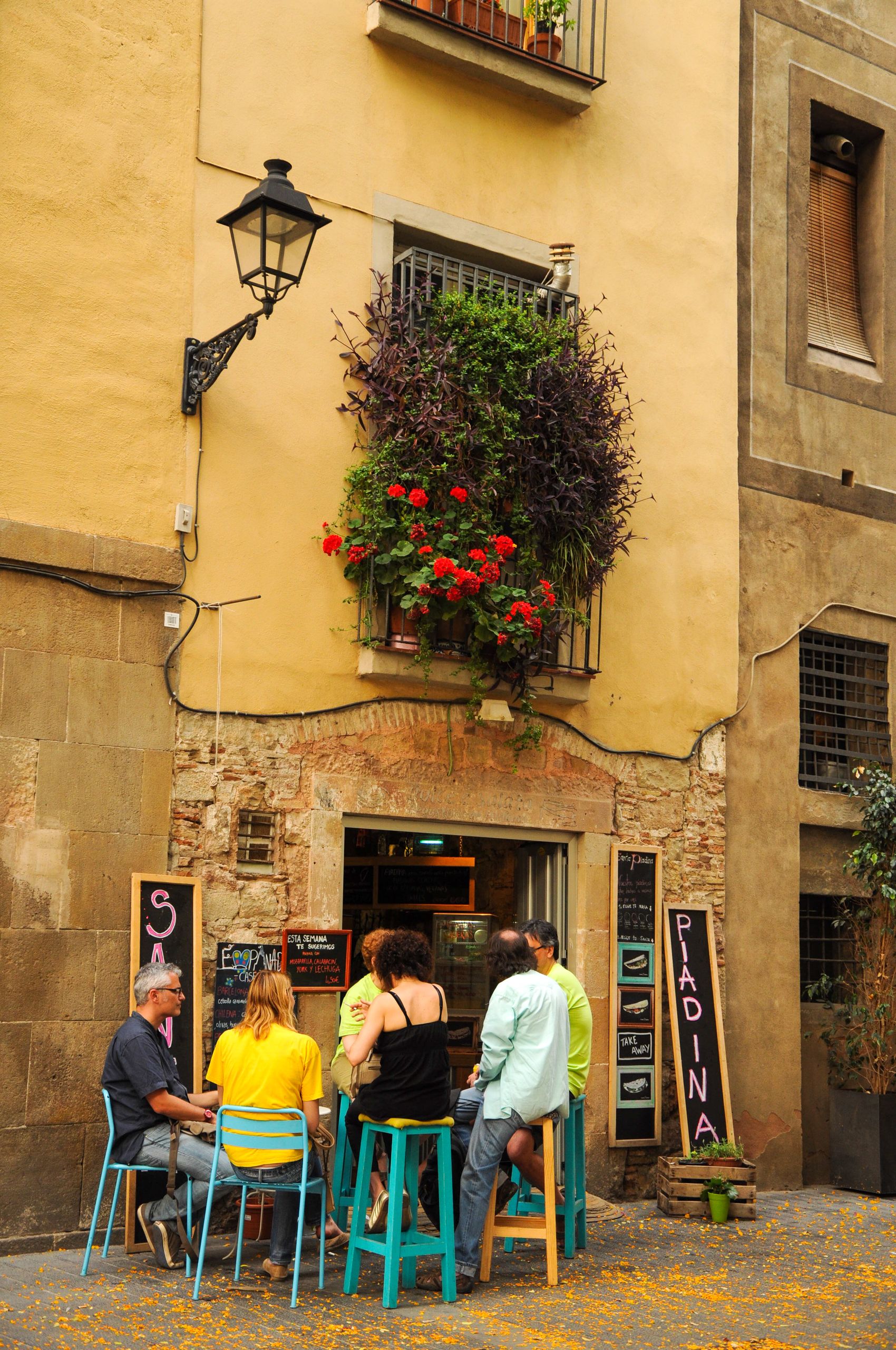 Group enjoying drinks at a quaint café on a picturesque Barcelona street.