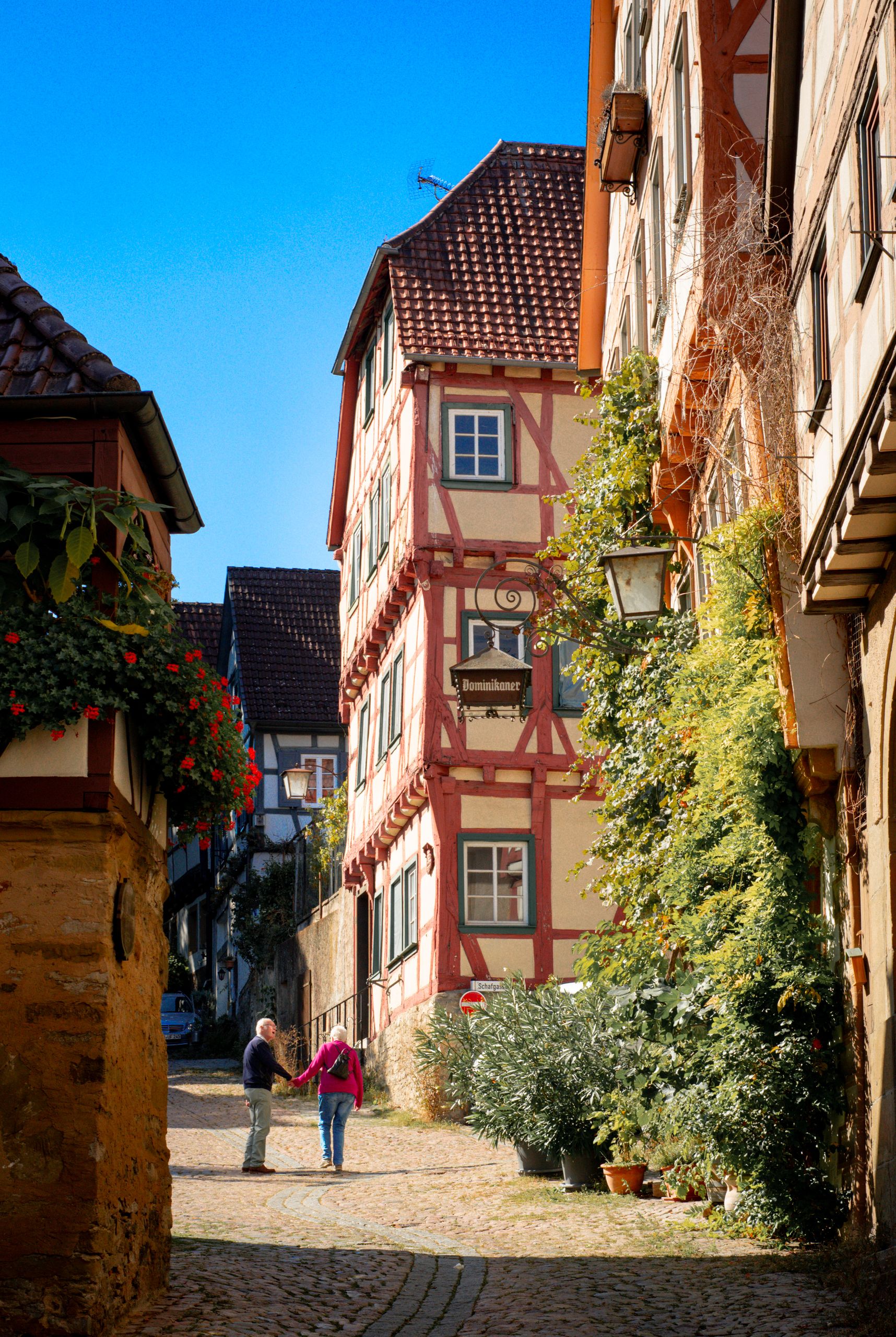 A picturesque view of a couple walking in historic Bad Wimpfen, Germany.