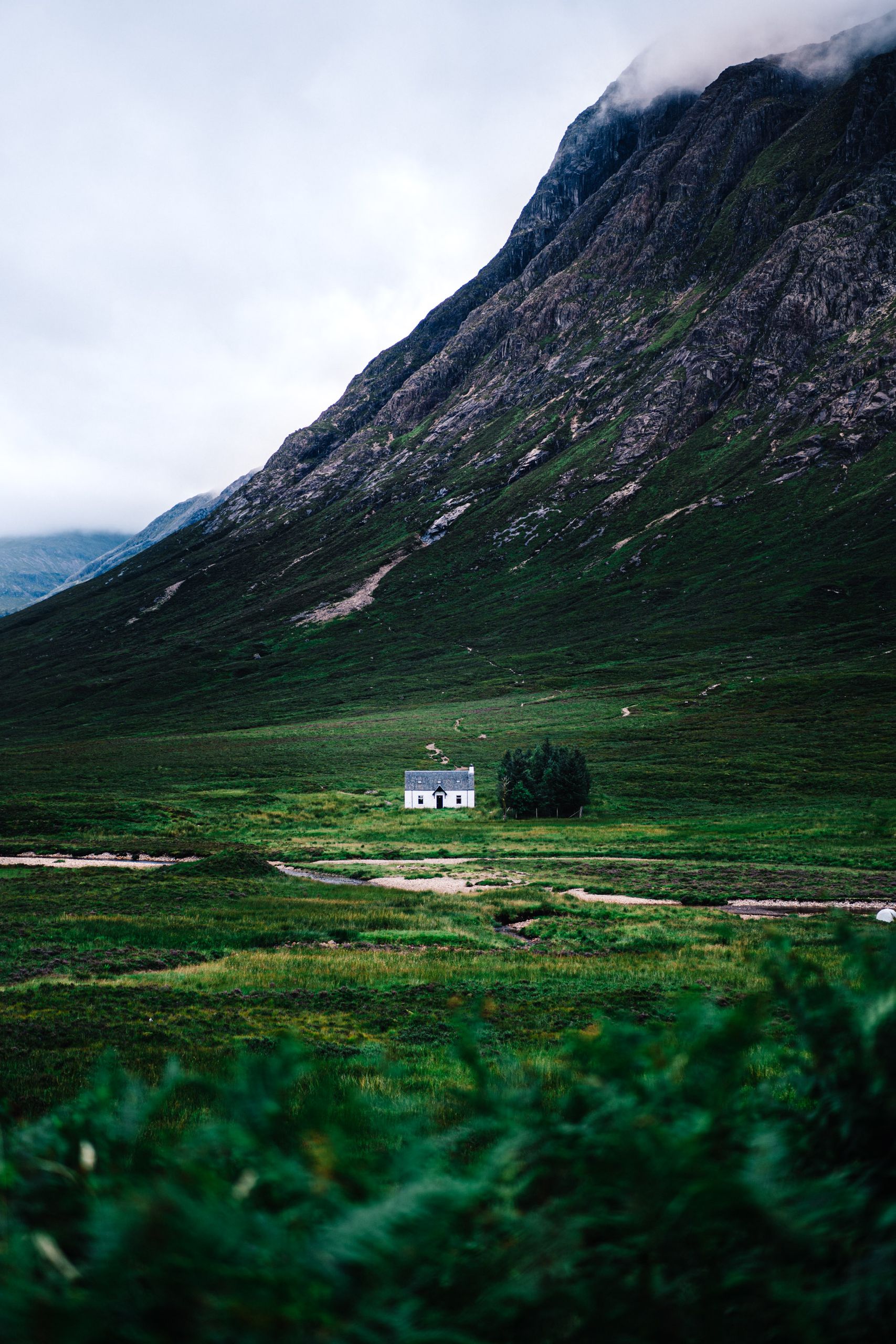 Explore the serene highlands of Scotland with a picturesque valley and white house.