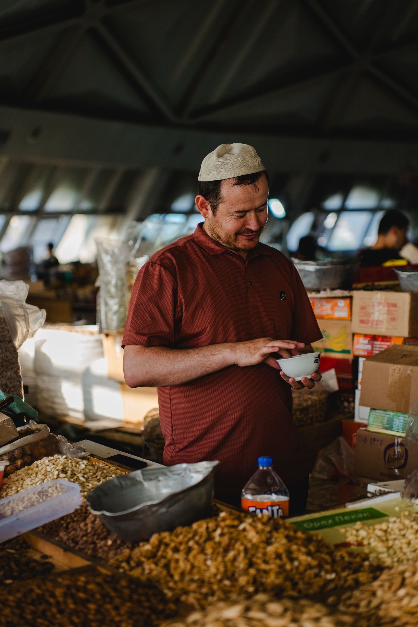 Man shopping for nuts and spices in an indoor market, enjoying local flavors.
